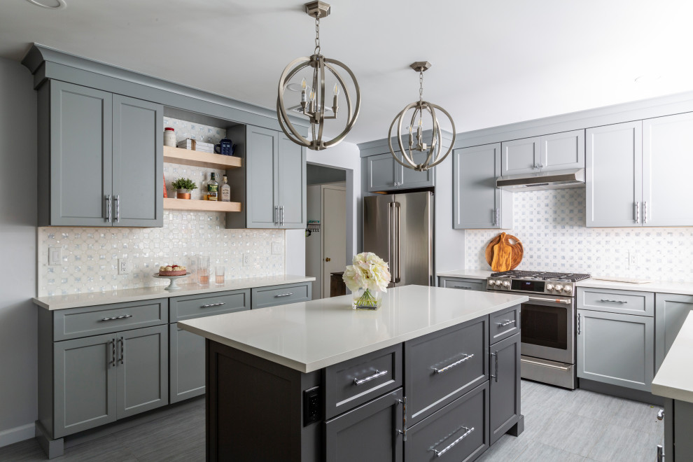 Example of a mid-sized transitional u-shaped porcelain tile and gray floor eat-in kitchen design in New York with shaker cabinets, blue cabinets, quartz countertops, white backsplash, mosaic tile backsplash, stainless steel appliances, an island, white countertops and a farmhouse sink