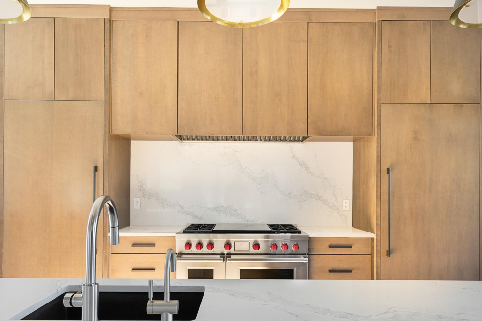 Large transitional l-shaped medium tone wood floor, brown floor and vaulted ceiling open concept kitchen photo in Seattle with an undermount sink, flat-panel cabinets, medium tone wood cabinets, quartz countertops, white backsplash, quartz backsplash, stainless steel appliances, an island and white countertops