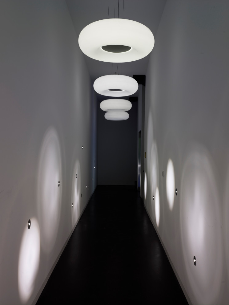 На фото: большой коридор в современном стиле с белыми стенами и черным полом с