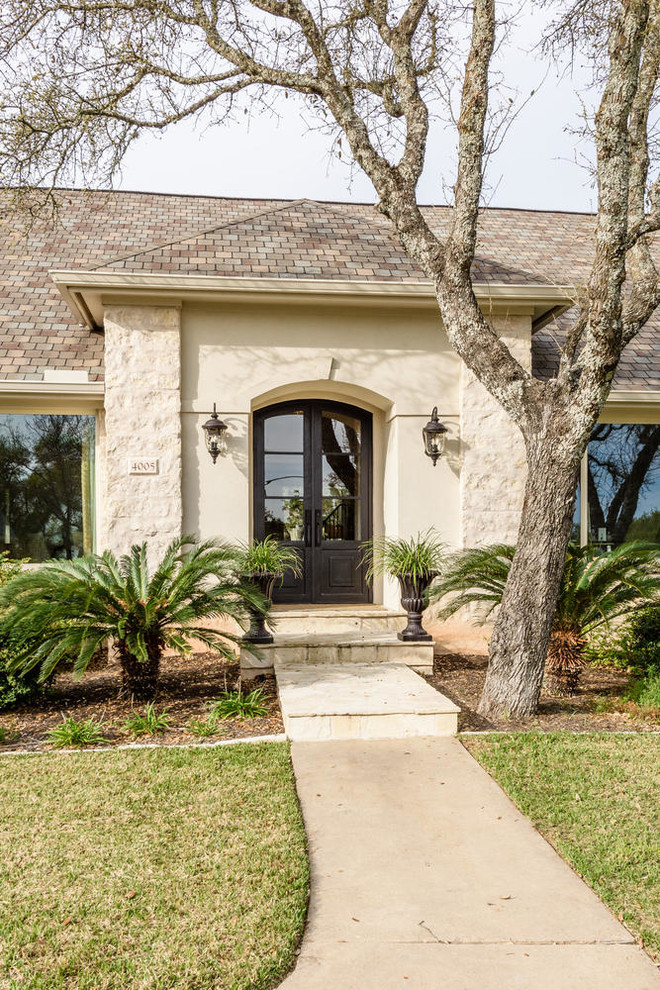 This is an example of a large transitional front door in Austin with a double front door and a black front door.