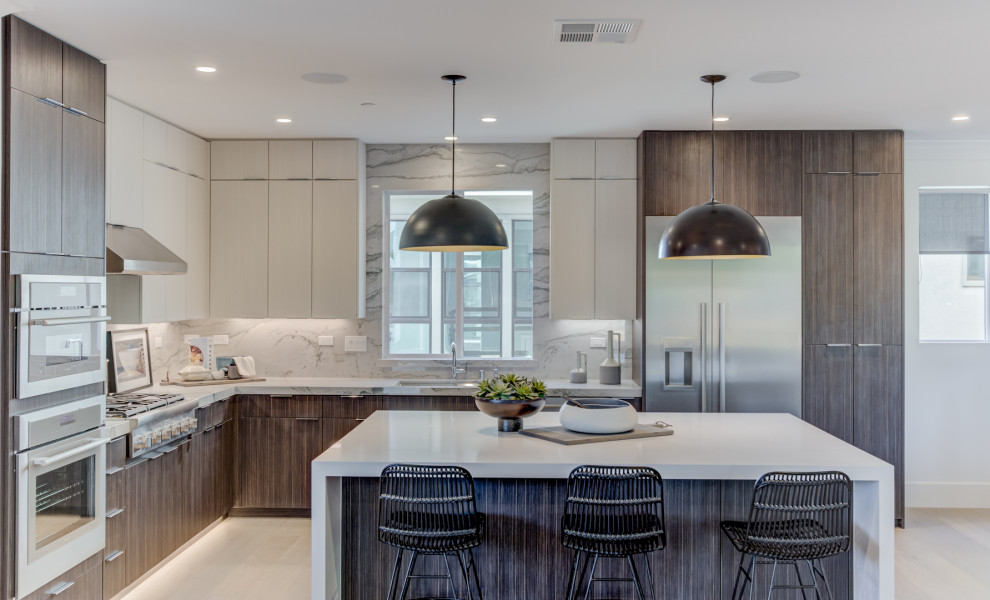 Design ideas for a contemporary l-shaped kitchen in San Francisco with stainless steel appliances, with island, an undermount sink, flat-panel cabinets, grey cabinets, white splashback, stone slab splashback, beige floor and white benchtop.