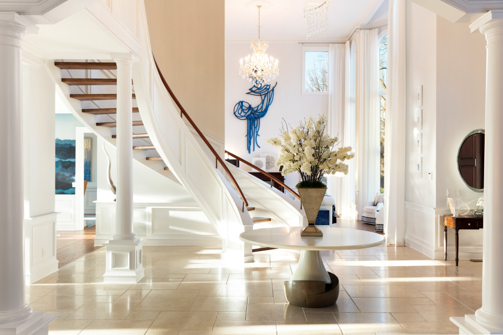 This is an example of an expansive beach style foyer in New York with white walls, travertine floors, a single front door, a white front door and beige floor.