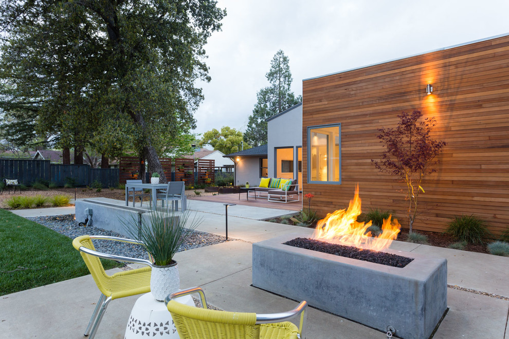 Photo of a large midcentury backyard patio in San Francisco with a fire feature, concrete slab and no cover.