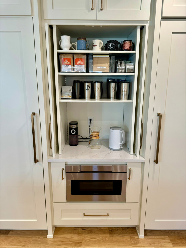Inspiration for a mid-sized transitional l-shaped light wood floor, brown floor and wallpaper ceiling eat-in kitchen remodel in Atlanta with a farmhouse sink, shaker cabinets, white cabinets, granite countertops, white backsplash, stainless steel appliances, an island and white countertops