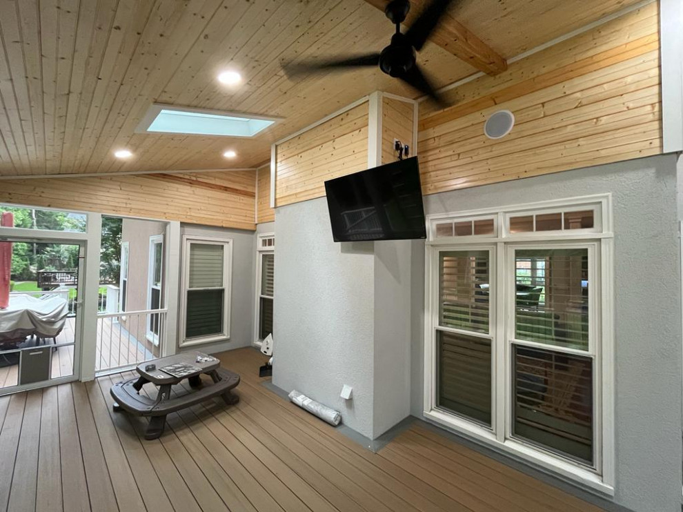 Photo of a large modern back metal railing veranda in Atlanta with skirting, concrete slabs and a roof extension.