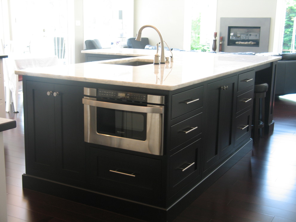 Example of a large transitional l-shaped dark wood floor eat-in kitchen design in Indianapolis with an undermount sink, recessed-panel cabinets, white cabinets, laminate countertops, white backsplash, ceramic backsplash, stainless steel appliances and an island