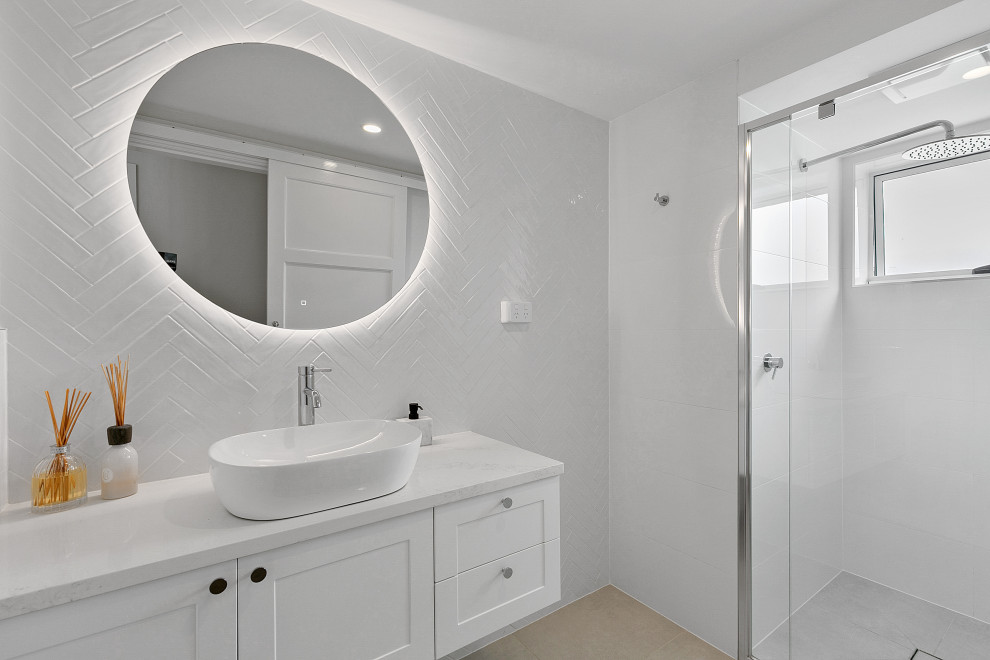 Photo of a beach style 3/4 bathroom in Brisbane with shaker cabinets, white cabinets, an alcove shower, white tile, white walls, a vessel sink, beige floor, a sliding shower screen, white benchtops, a single vanity and a floating vanity.