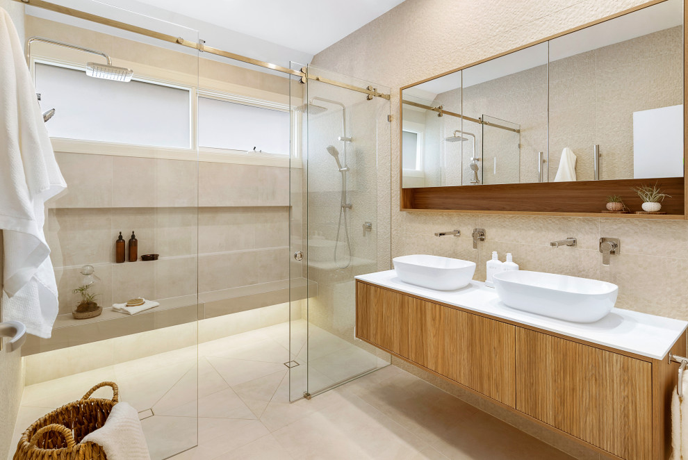 Design ideas for a large contemporary master bathroom in Melbourne with medium wood cabinets, a double shower, beige tile, porcelain tile, porcelain floors, a vessel sink, engineered quartz benchtops, beige floor, a sliding shower screen, white benchtops, a shower seat, a double vanity, a floating vanity and flat-panel cabinets.