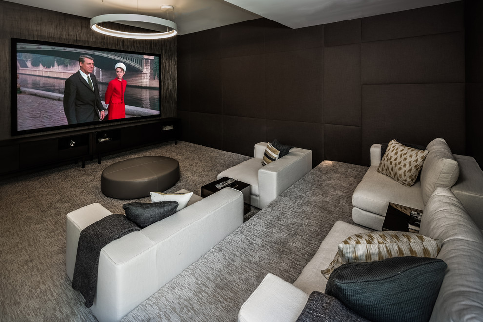 Contemporary enclosed home theatre in Los Angeles with black walls, carpet and grey floor.