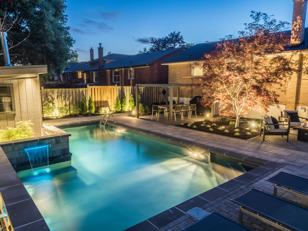 Pool fountain - mid-sized transitional backyard concrete paver and l-shaped lap pool fountain idea in Toronto
