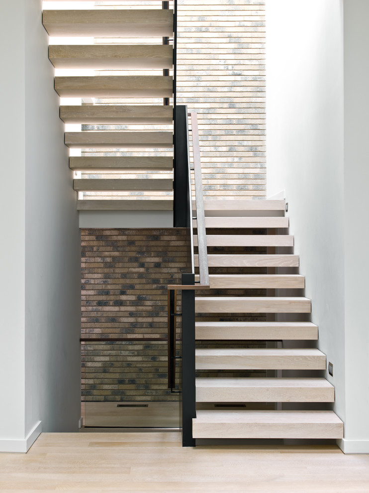 Inspiration for a mid-sized contemporary wood u-shaped staircase in Chicago with open risers.