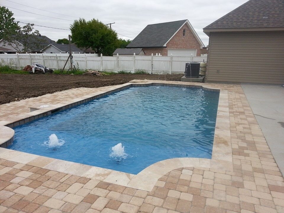 Design ideas for an arts and crafts custom-shaped pool in New Orleans with a water feature and natural stone pavers.