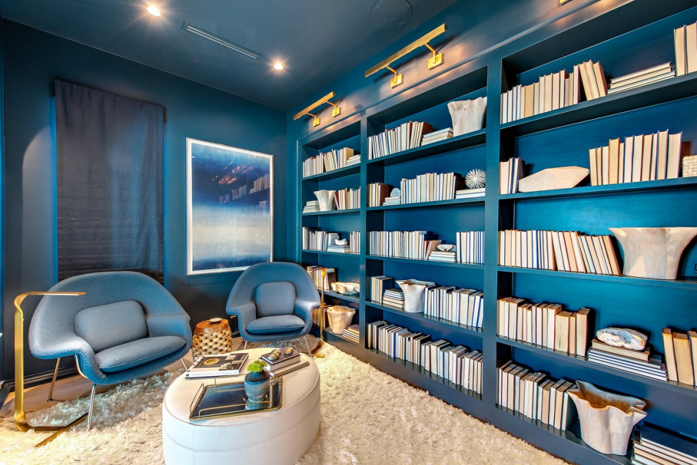 Exempel på ett maritimt arbetsrum, med ett bibliotek och blå väggar