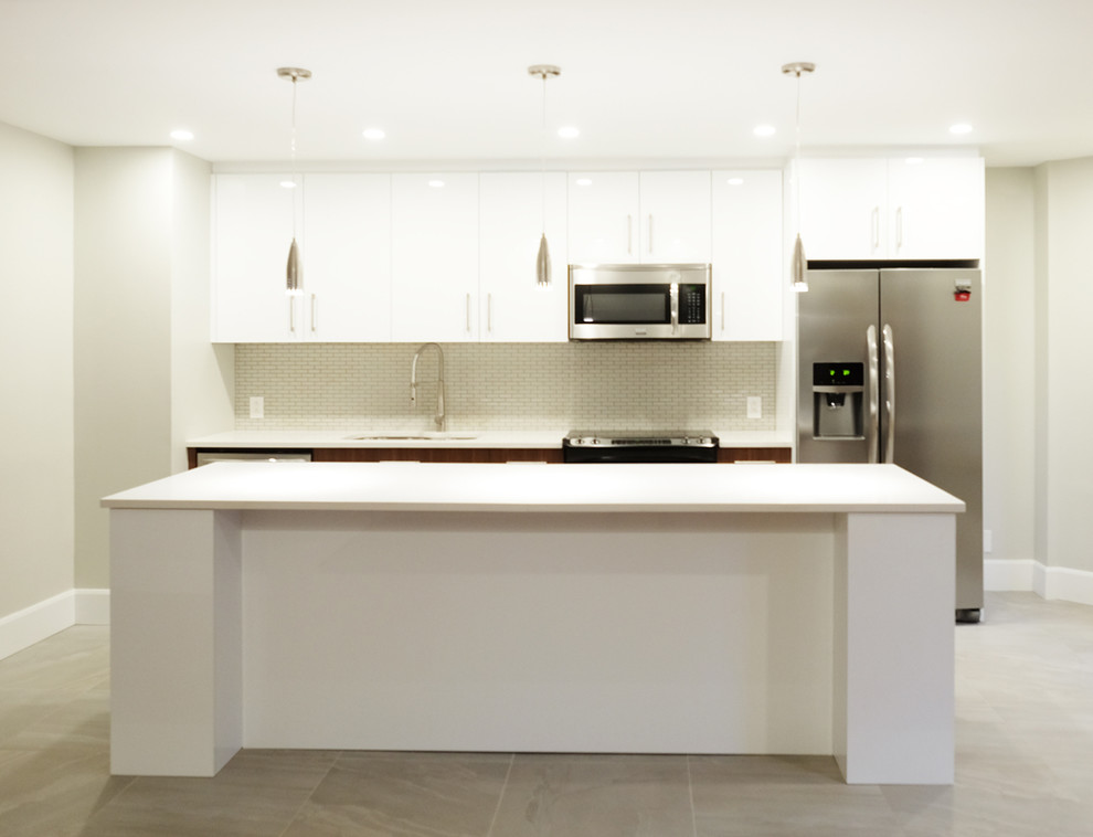 Design ideas for a large contemporary galley eat-in kitchen in Montreal with an undermount sink, flat-panel cabinets, white cabinets, quartz benchtops, grey splashback, mosaic tile splashback, stainless steel appliances, porcelain floors and with island.