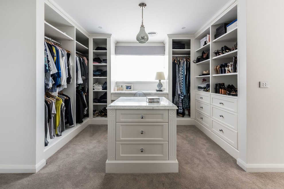 Photo of a large contemporary gender-neutral walk-in wardrobe with shaker cabinets, white cabinets and carpet.