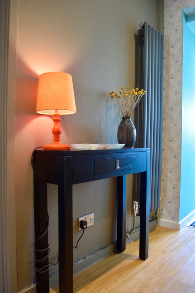 Idée de décoration pour un petit couloir design avec un mur bleu, un sol en bois brun, un sol marron et du papier peint.