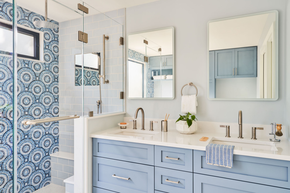 This is an example of a medium sized contemporary ensuite bathroom in Austin with shaker cabinets, blue cabinets, a corner shower, blue tiles, glass tiles, blue walls, a submerged sink, a hinged door, white worktops, double sinks and a built in vanity unit.