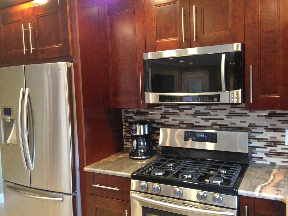 Example of a large minimalist l-shaped ceramic tile eat-in kitchen design in Tampa with an undermount sink, shaker cabinets, dark wood cabinets, granite countertops, multicolored backsplash, mosaic tile backsplash, stainless steel appliances and an island