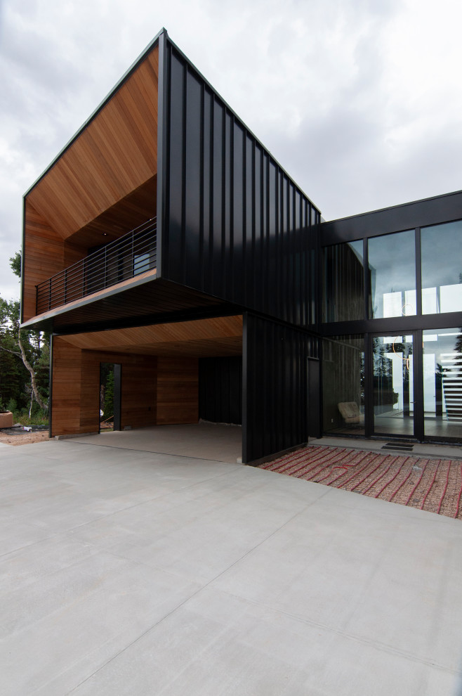Diseño de fachada de casa negra minimalista de dos plantas con revestimiento de madera, tejado de un solo tendido y panel y listón