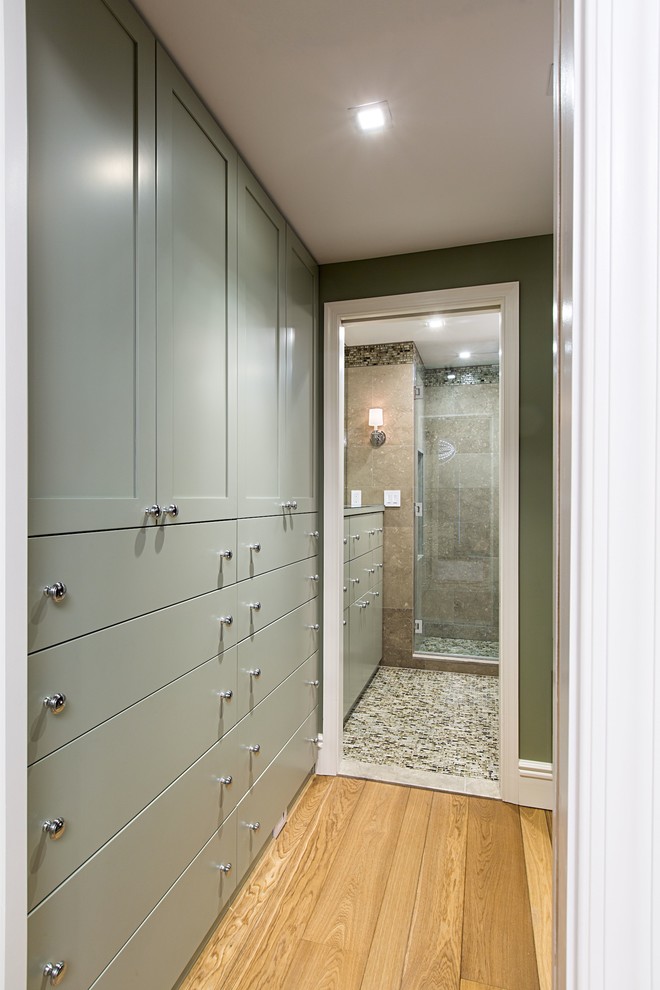 Inspiration for a transitional walk-in wardrobe in New York with recessed-panel cabinets, green cabinets and light hardwood floors.