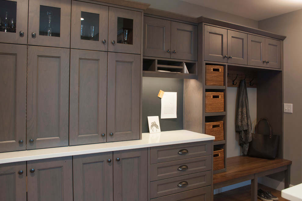 Inspiration for a mid-sized transitional galley medium tone wood floor and brown floor eat-in kitchen remodel in Burlington with a farmhouse sink, flat-panel cabinets, gray cabinets, quartz countertops, white backsplash, subway tile backsplash, stainless steel appliances and a peninsula