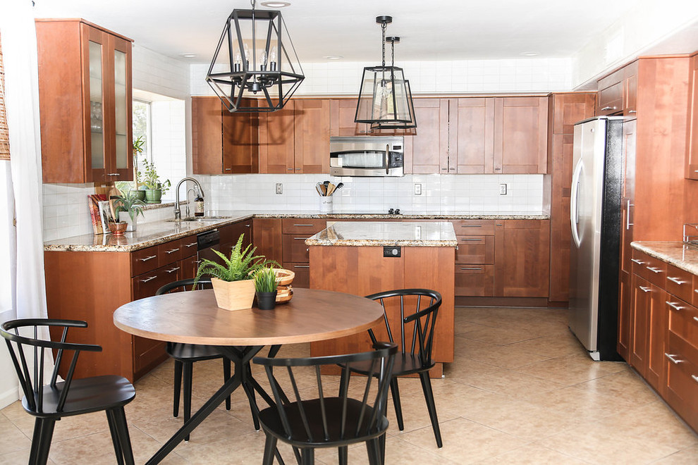 Mid-sized midcentury u-shaped open plan kitchen in Phoenix with a single-bowl sink, shaker cabinets, brown cabinets, granite benchtops, white splashback, subway tile splashback, stainless steel appliances, porcelain floors, with island, beige floor and beige benchtop.