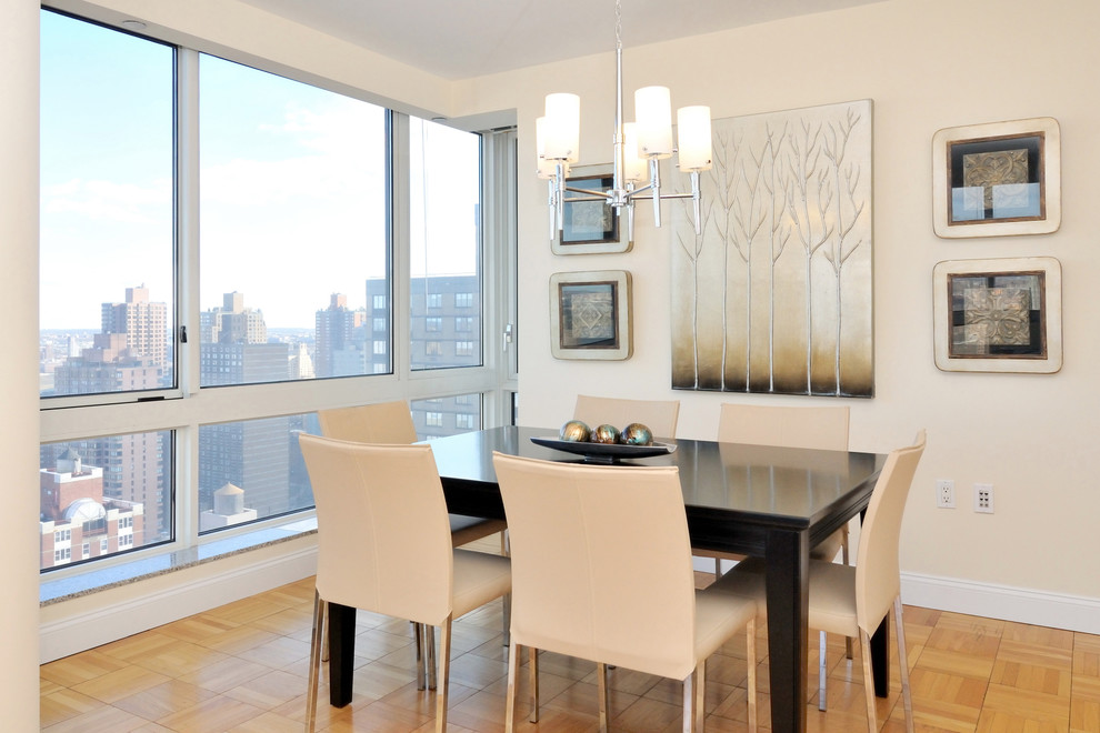 This is an example of a contemporary dining room in New York with beige walls and medium hardwood floors.