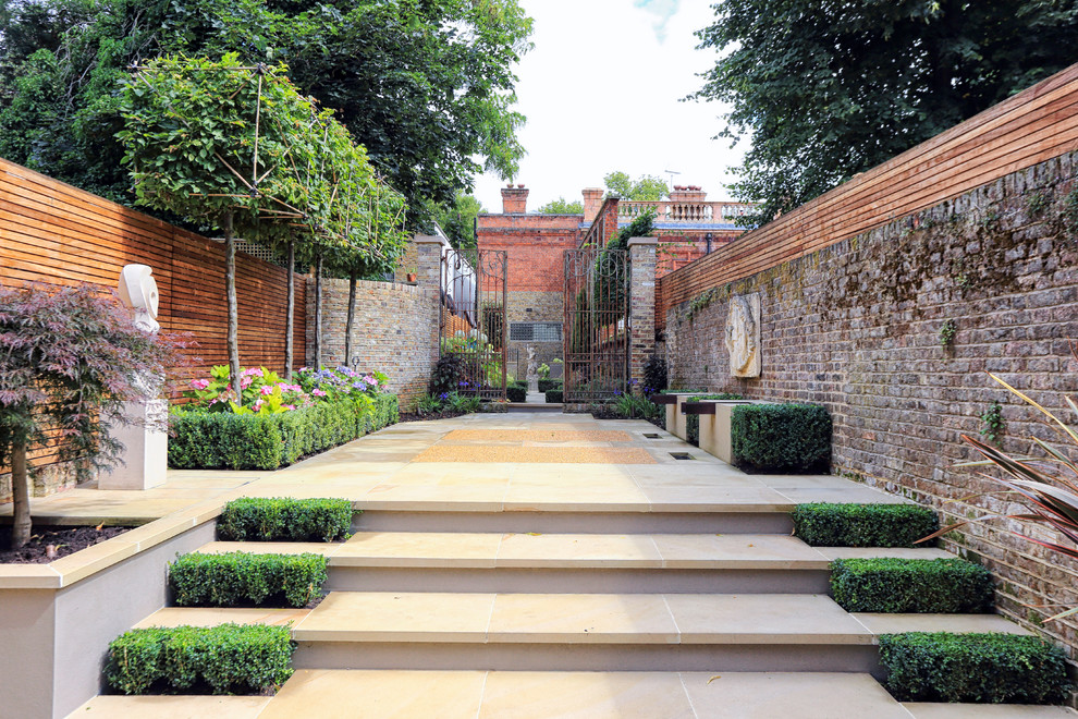 Photo of a traditional patio in London with natural stone pavers.