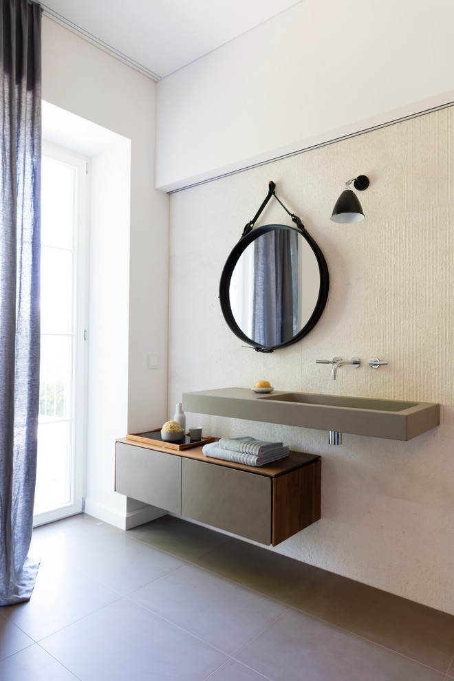 Photo of a large modern master bathroom in Other with flat-panel cabinets, grey cabinets, a curbless shower, a two-piece toilet, beige tile, limestone, white walls, limestone floors, an integrated sink, limestone benchtops, grey floor and grey benchtops.