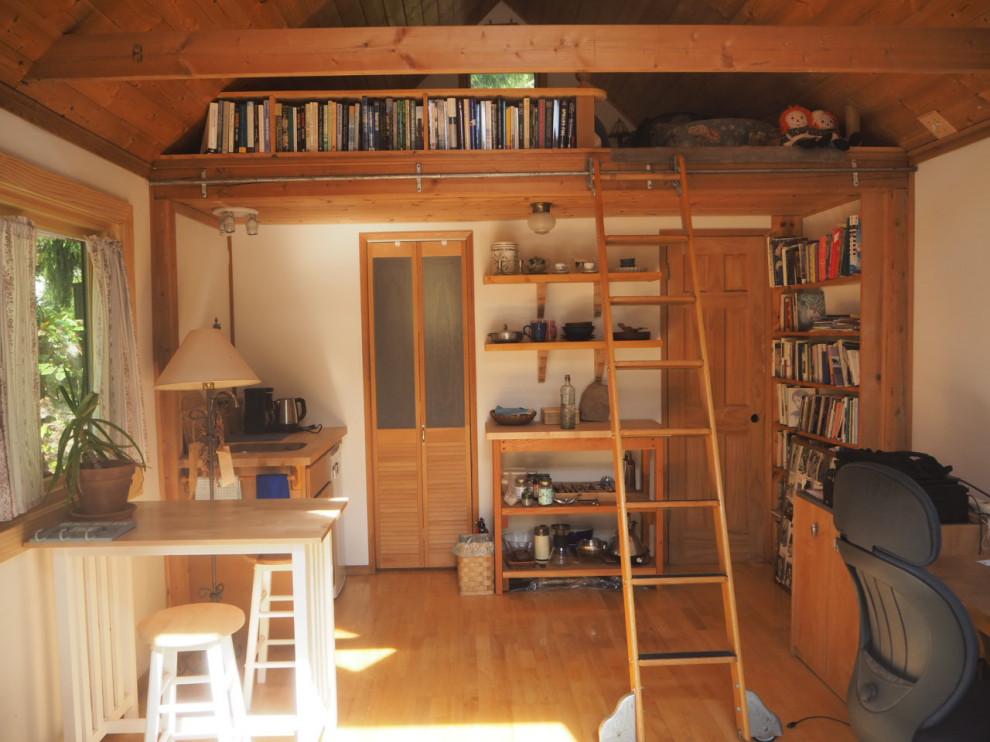 Bild på ett litet rustikt brun linjärt brunt kök med öppen planlösning, med en undermonterad diskho, släta luckor, skåp i ljust trä, träbänkskiva, vita vitvaror, mellanmörkt trägolv och brunt golv