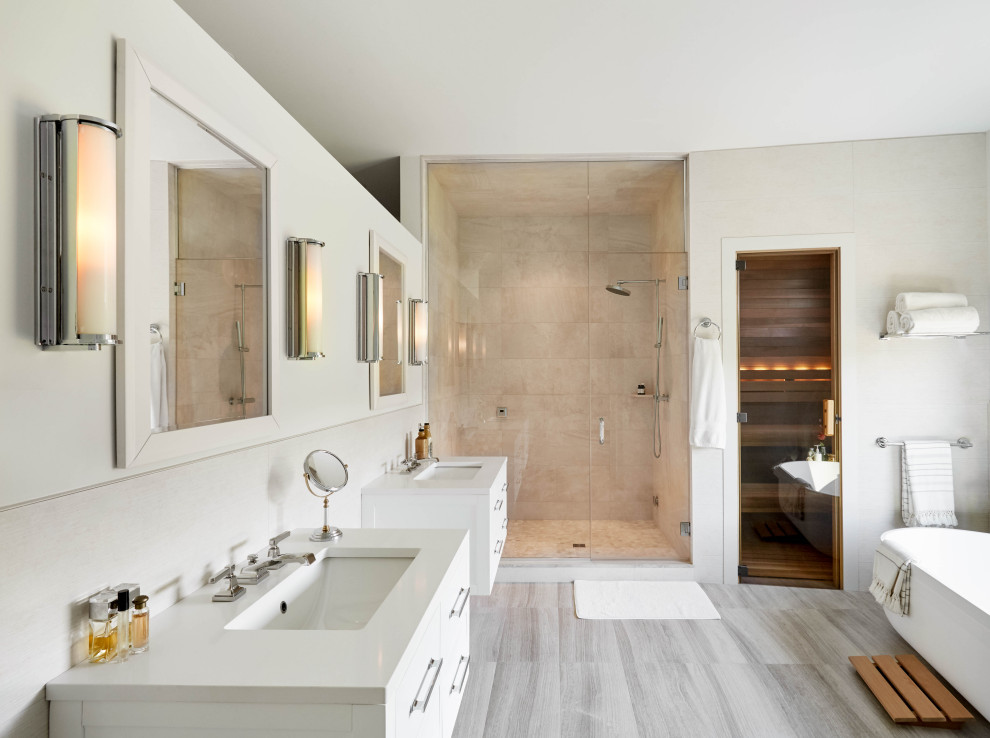 Inredning av ett modernt stort en-suite badrum, med släta luckor, vita skåp, ett fristående badkar, en dubbeldusch, ett undermonterad handfat, grått golv och dusch med gångjärnsdörr