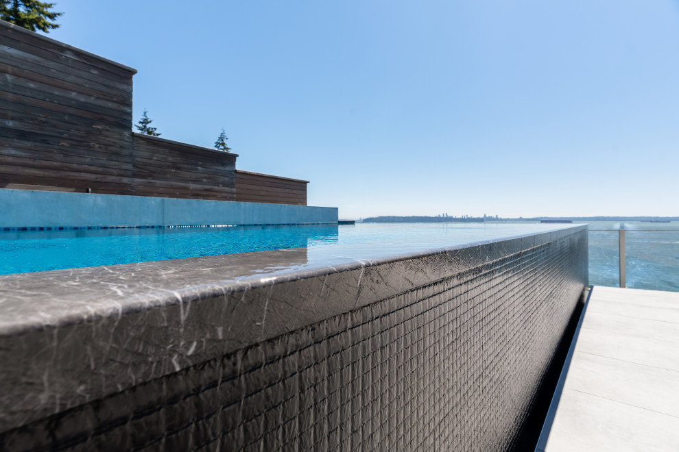 Idee per una piscina a sfioro infinito moderna rettangolare di medie dimensioni e dietro casa con piastrelle