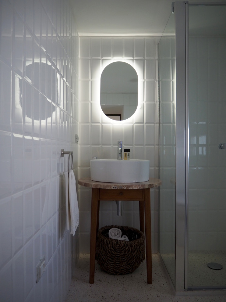 На фото: маленькая ванная комната в стиле фьюжн с светлыми деревянными фасадами, душем без бортиков, унитазом-моноблоком, белой плиткой, плиткой кабанчик, белыми стенами, полом из цементной плитки, душевой кабиной, настольной раковиной, мраморной столешницей, душем с распашными дверями, розовой столешницей, тумбой под одну раковину и напольной тумбой для на участке и в саду