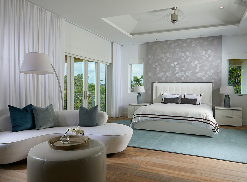Photo of a contemporary master bedroom in Miami with light hardwood floors.