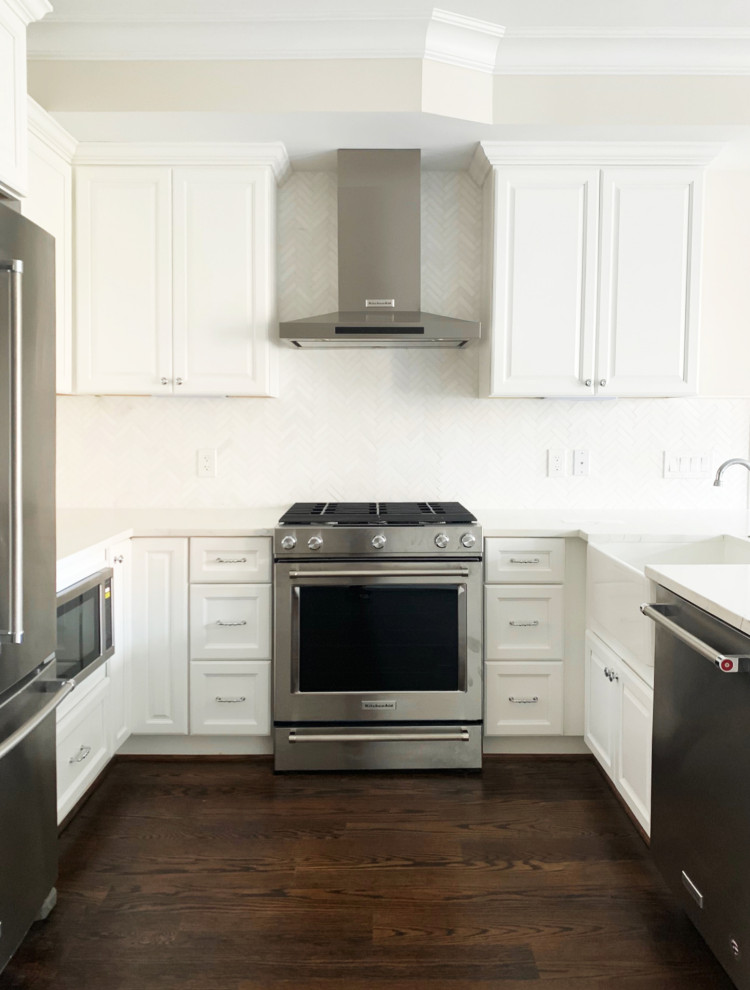 Inspiration for a small traditional u-shaped open plan kitchen in DC Metro with a farmhouse sink, recessed-panel cabinets, white cabinets, quartzite benchtops, white splashback, marble splashback, stainless steel appliances, dark hardwood floors, no island, brown floor and white benchtop.