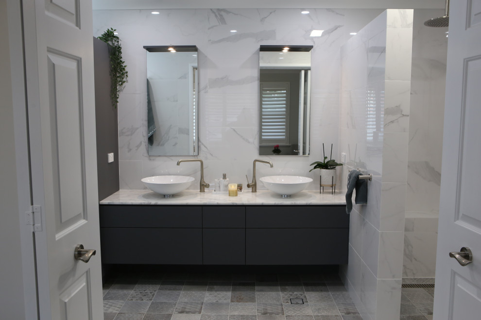 Design ideas for an expansive beach style master bathroom in Perth with flat-panel cabinets, grey cabinets, an open shower, a wall-mount toilet, white tile, marble, white walls, mosaic tile floors, a vessel sink, marble benchtops, grey floor, white benchtops, a shower seat, a double vanity and a built-in vanity.