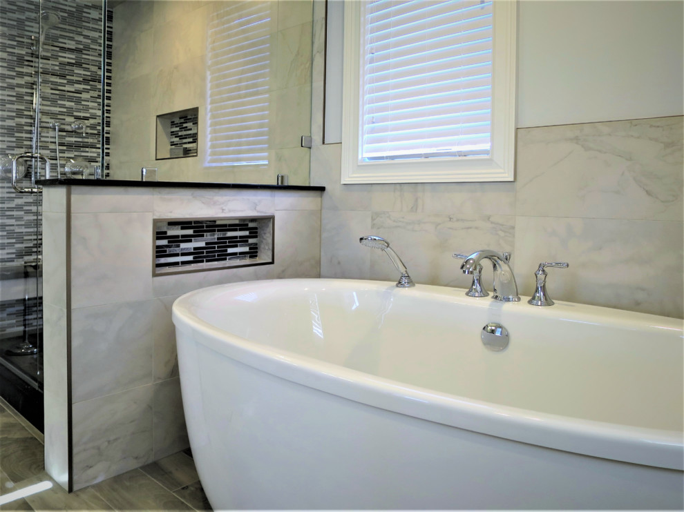 Inspiration for a mid-sized transitional master gray tile and porcelain tile porcelain tile and gray floor freestanding bathtub remodel with shaker cabinets, white cabinets, a one-piece toilet, blue walls, an integrated sink, solid surface countertops and a hinged shower door