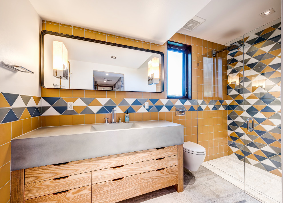 Mid-sized eclectic kids bathroom in Seattle with light wood cabinets, an alcove shower, a wall-mount toilet, multi-coloured tile, ceramic tile, grey floor, a hinged shower door, grey benchtops and a single vanity.
