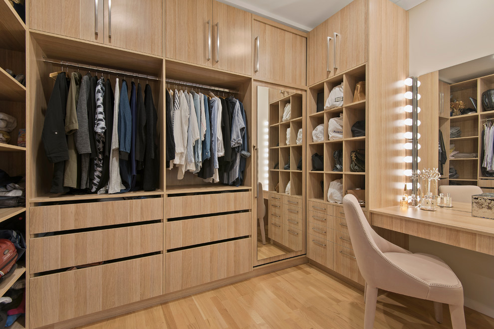 Mid-sized contemporary gender-neutral walk-in wardrobe in Brisbane with light wood cabinets, plywood floors, beige floor and flat-panel cabinets.