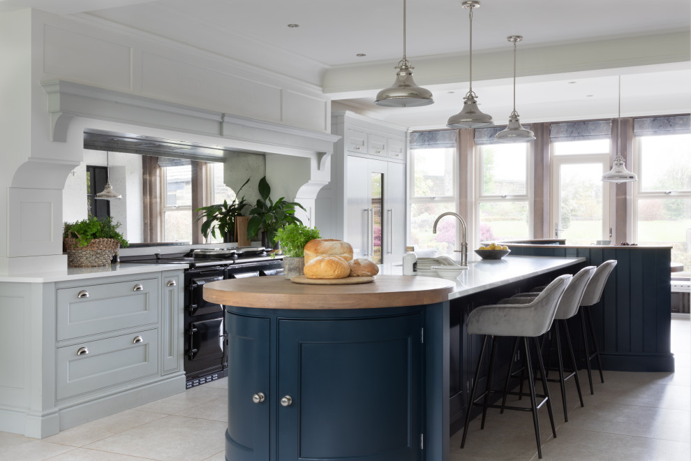 Large traditional open plan kitchen in Manchester with an integrated sink, shaker cabinets, black cabinets, quartzite benchtops, metallic splashback, mirror splashback, stainless steel appliances, limestone floors, multiple islands, grey floor, white benchtop and coffered.