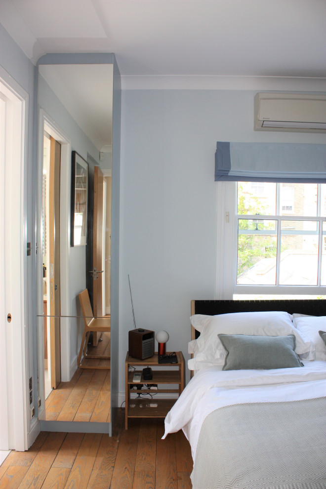 Diseño de dormitorio principal escandinavo de tamaño medio con paredes azules y suelo de madera en tonos medios