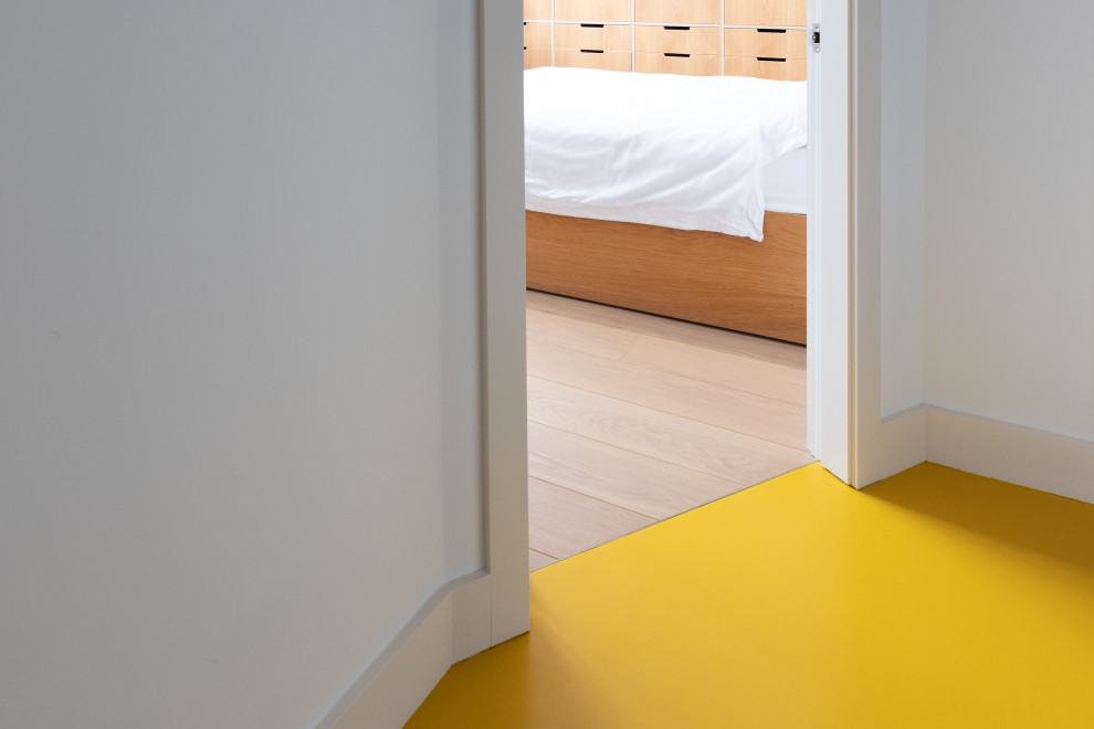 Inspiration pour un petit couloir avec un mur blanc et un sol jaune.