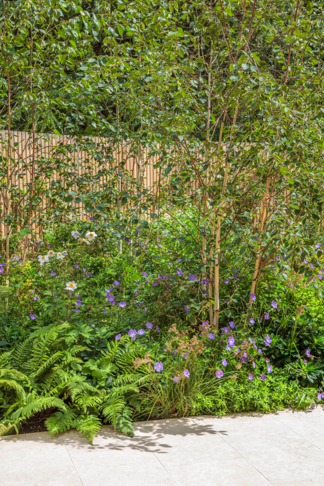 Immagine di un giardino minimal esposto a mezz'ombra di medie dimensioni e dietro casa in estate con pavimentazioni in pietra naturale e recinzione in legno