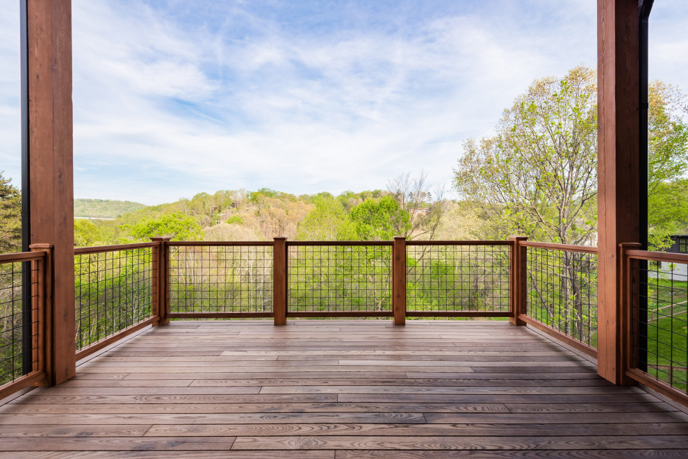 Example of a mid-sized transitional backyard ground level mixed material railing deck design with a roof extension