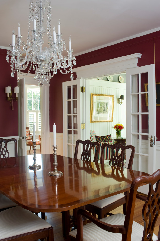 This is an example of a mid-sized country separate dining room in Boston with red walls and light hardwood floors.