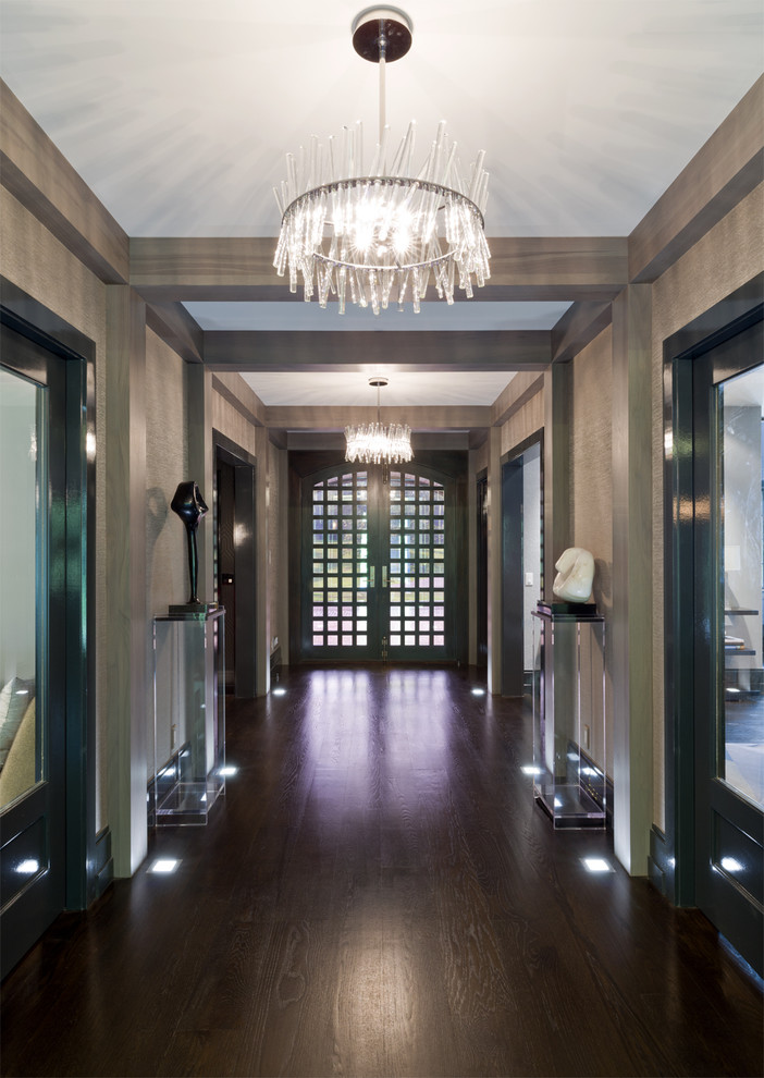 This is an example of a large contemporary entry hall in New York with metallic walls, dark hardwood floors, a double front door and a dark wood front door.