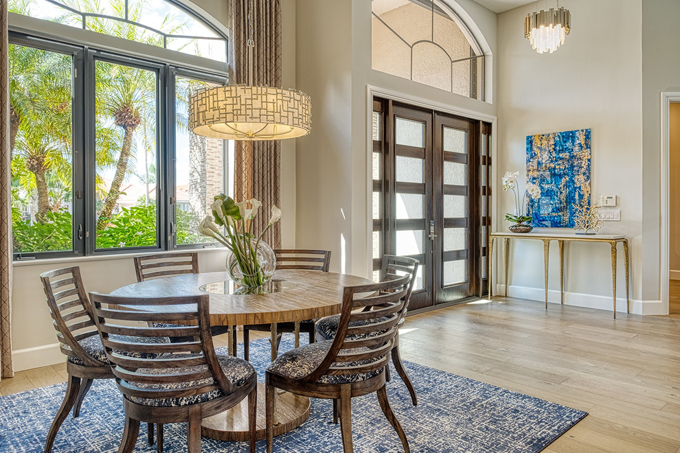 Mediterranean dining room in Miami with grey walls, medium hardwood floors and beige floor.