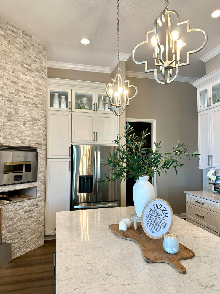 Inspiration for a transitional kitchen remodel in Orlando with raised-panel cabinets, white cabinets, quartz countertops, stainless steel appliances, an island and white countertops