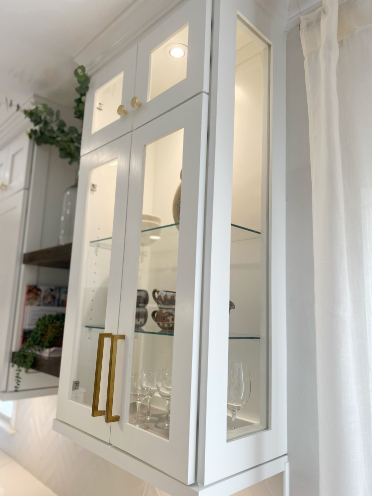 This is an example of a medium sized traditional l-shaped kitchen pantry in Atlanta with a submerged sink, shaker cabinets, white cabinets, engineered stone countertops, white splashback, glass tiled splashback, integrated appliances, a breakfast bar and grey worktops.