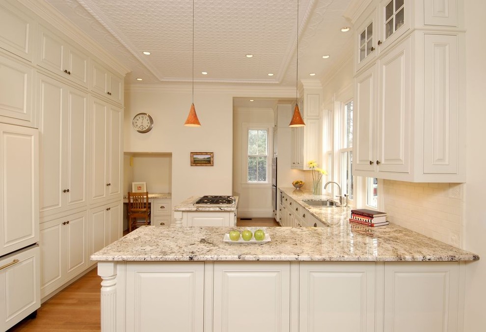 This is an example of a traditional kitchen in Boston with raised-panel cabinets, beige cabinets and panelled appliances.